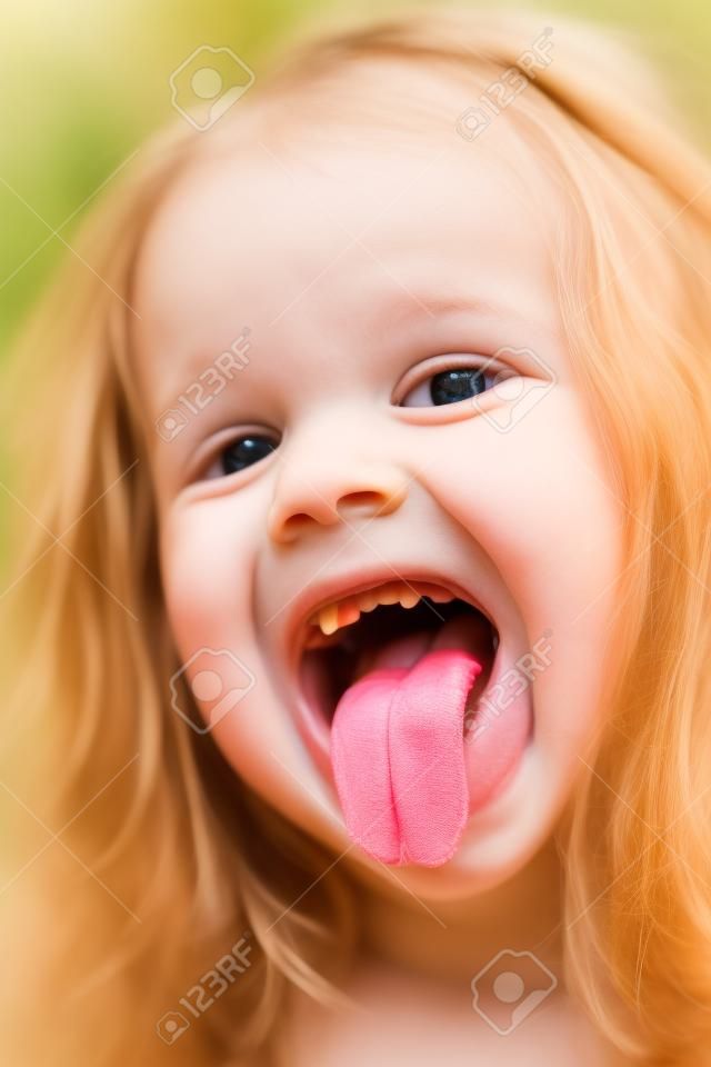 Retrato de portarretrato de divertida niña sonriente con la lengua fuera y sin un diente frontal