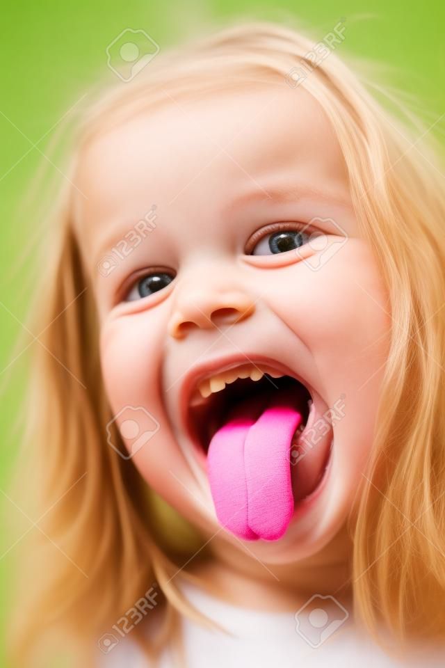Closeup Portrait of funny lächelnd mädchen mit Zunge heraus und ohne einen vorderen Zahn