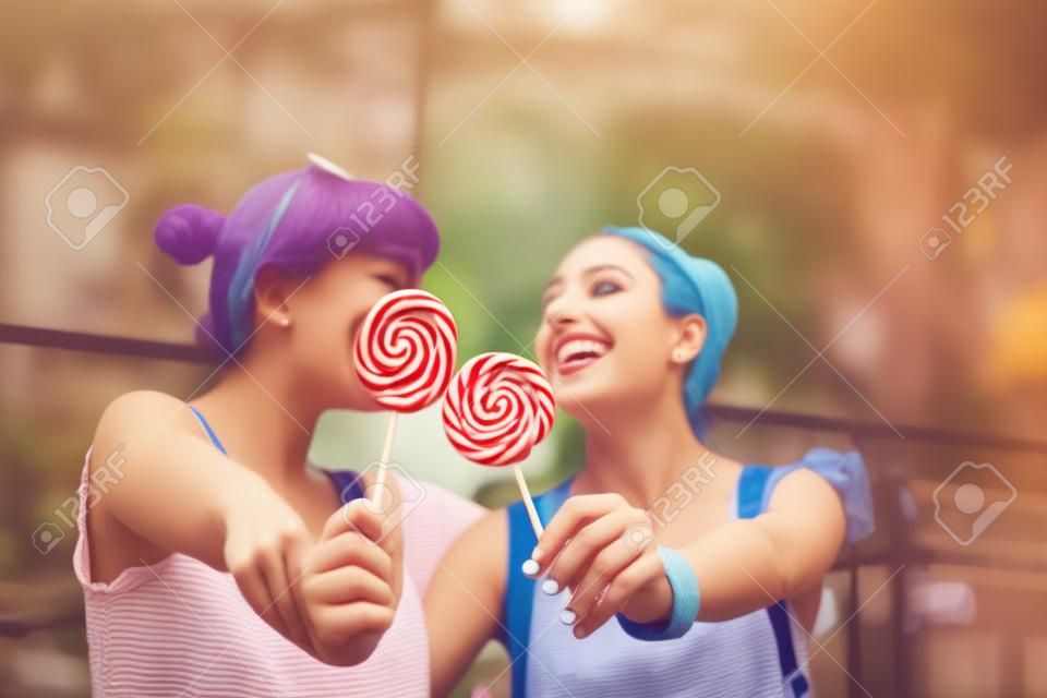 롤리팝을 먹는 행복한 젊은 여성들