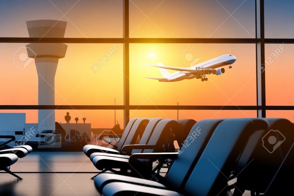 Lege stoelen in de vertrekhal op de luchthaven, met de controletoren en een vliegtuig opstijgen bij zonsondergang. Reizen en vervoer concepten.