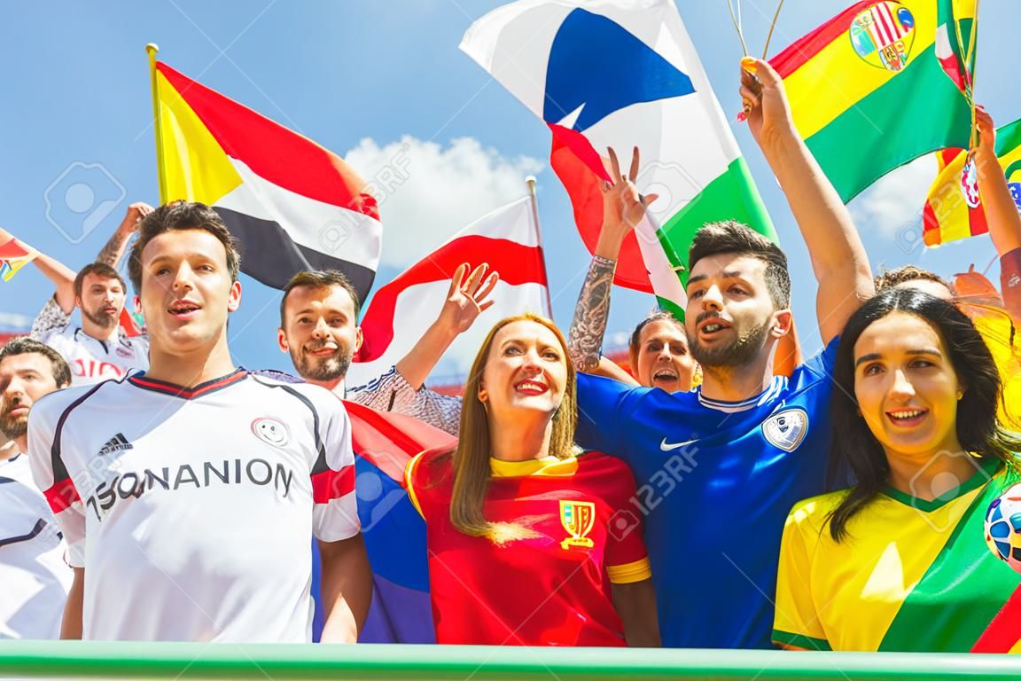 Happy supporters from different countries together at stadium. Fans from France, Germany, Spain, Brazil and other countries enjoying a match together. Sport, respect and fair play concepts