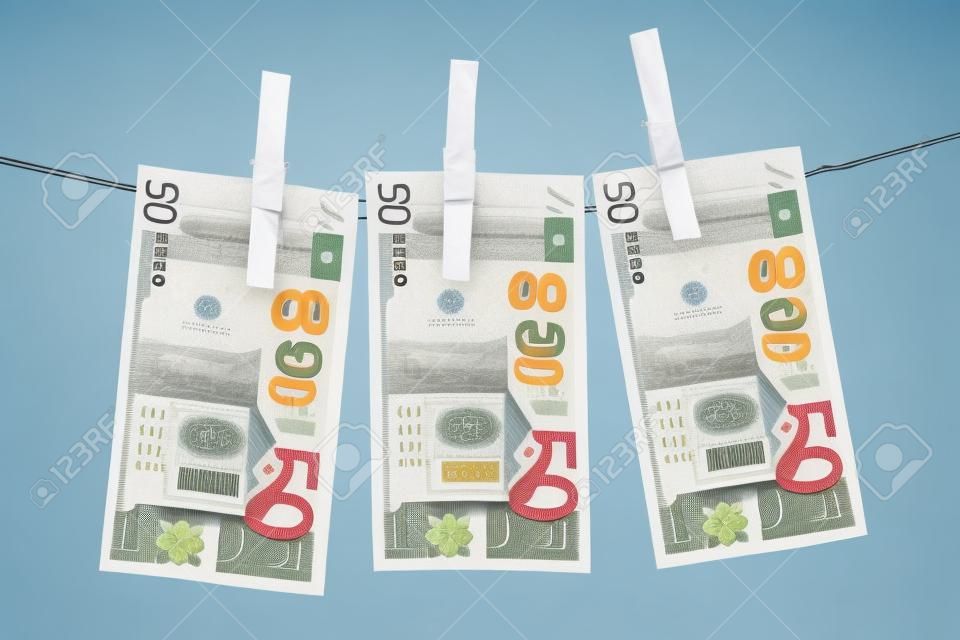 Three fifty euro bills hanging on a clothesline. Isolated on a white background.