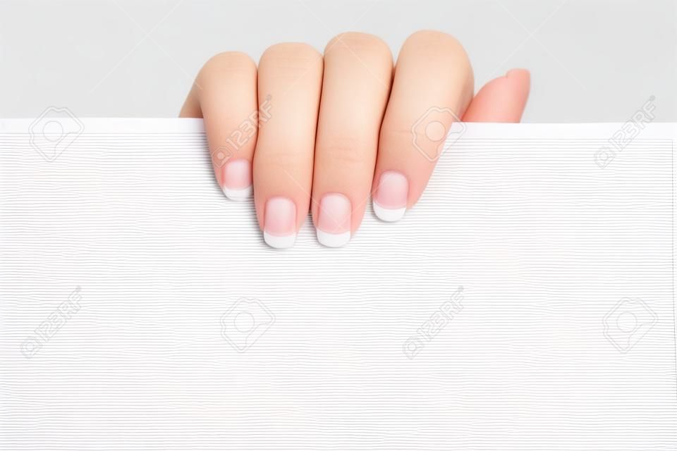 Female hand holding a blank sheet of paper. Isolated on a white background.