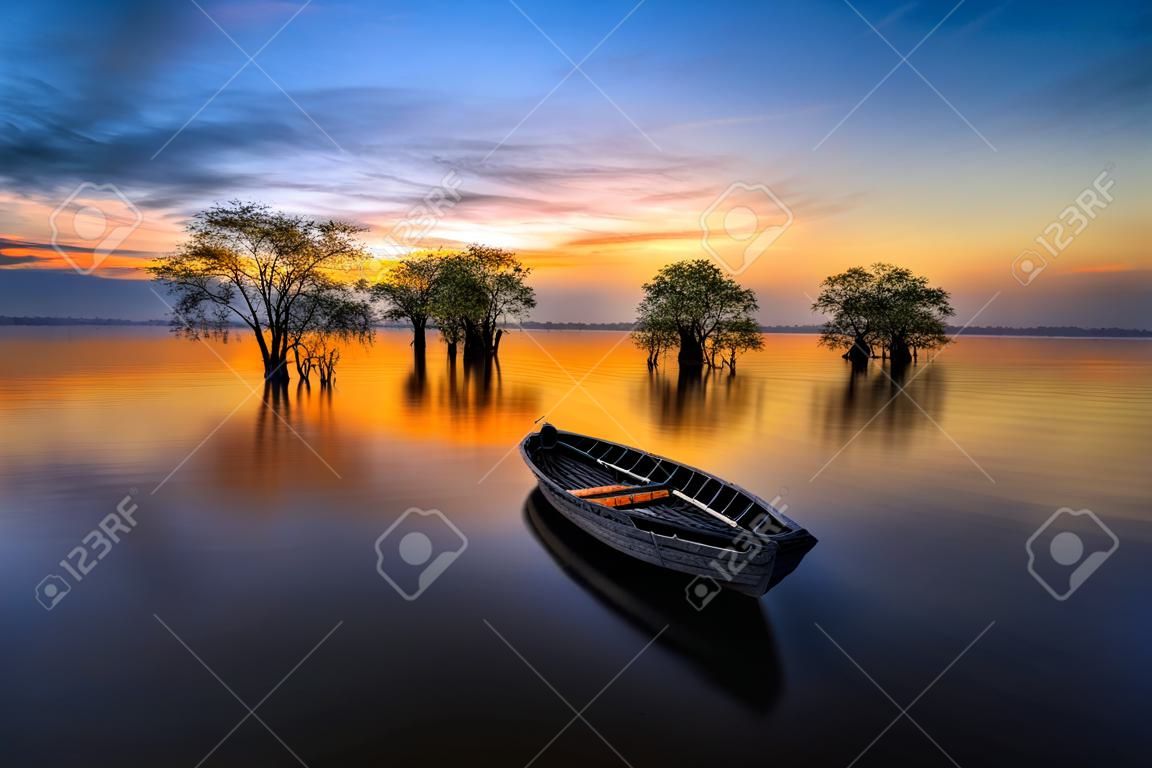 bateau pêcheur et arbres dans le lac avec belle lumière du soleil