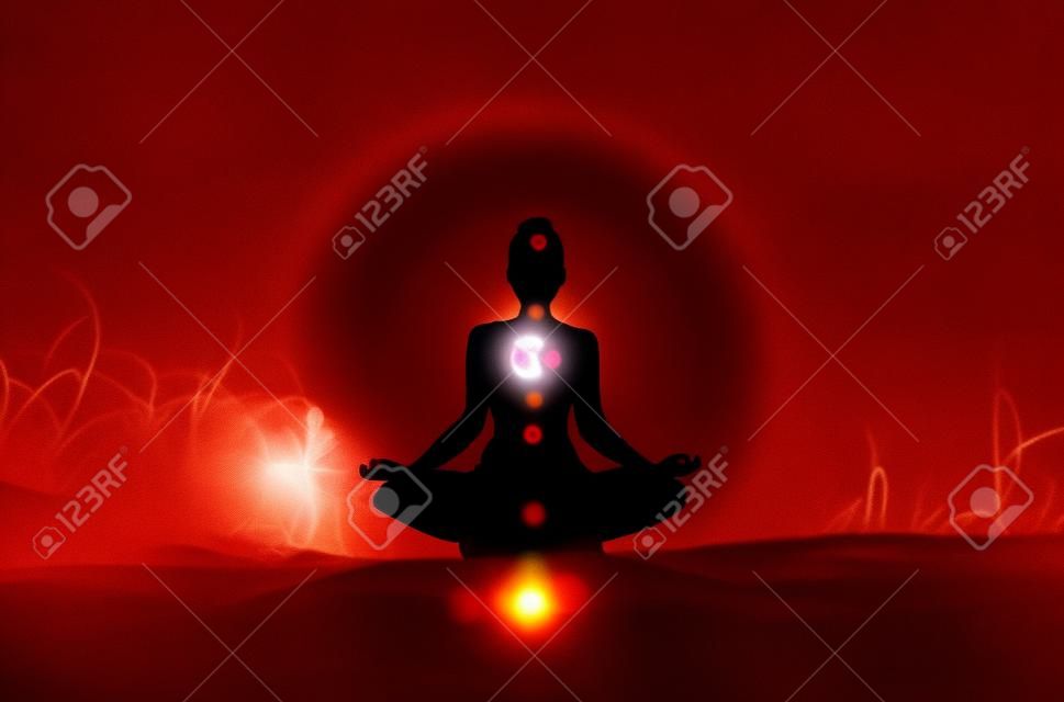 A silhouette of a person doing yoga with the root chakra symbol