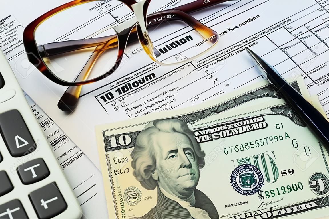 ペン、電卓、ドル紙幣、メガネ課税概念と申告