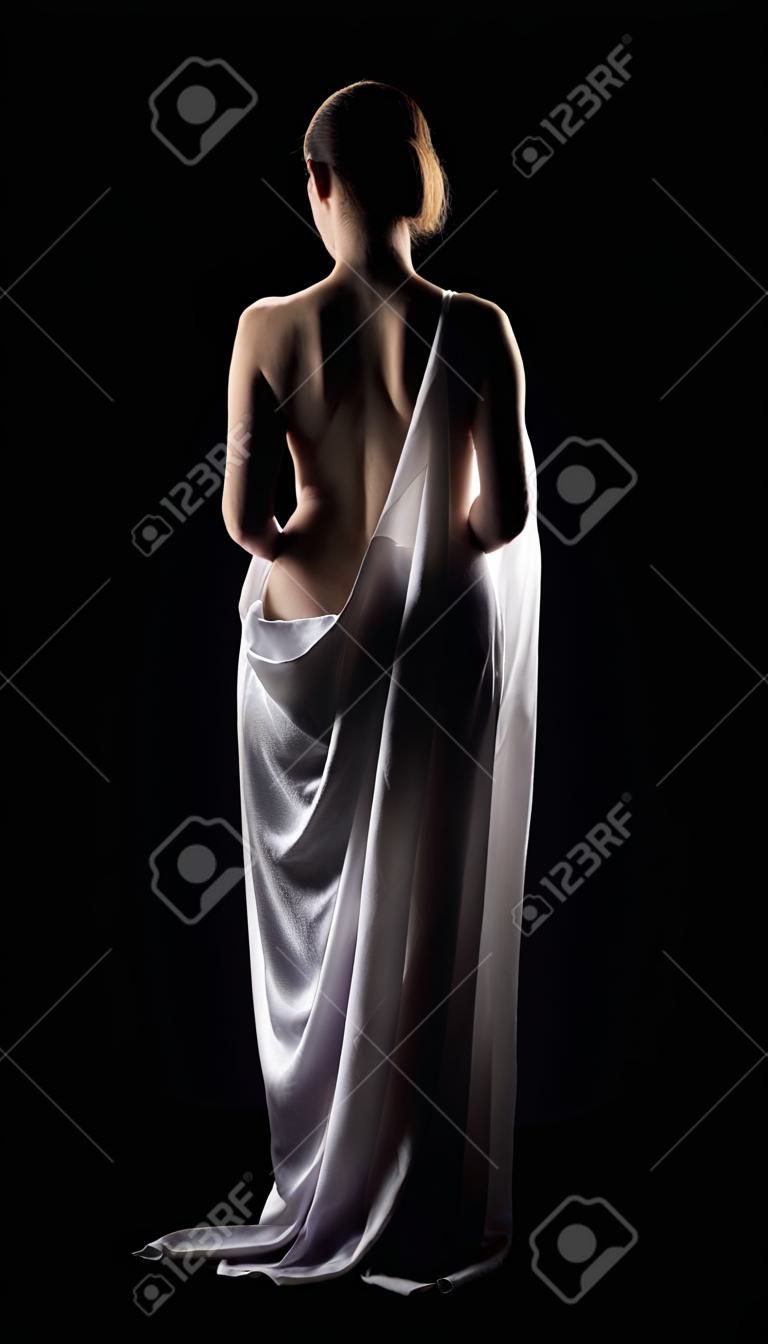 Belle femme posant comme statue en noir avec un chiffon