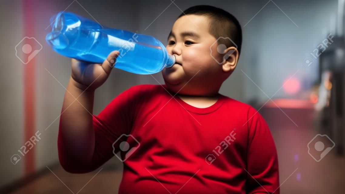 Asian Fat boy is drinking a cola