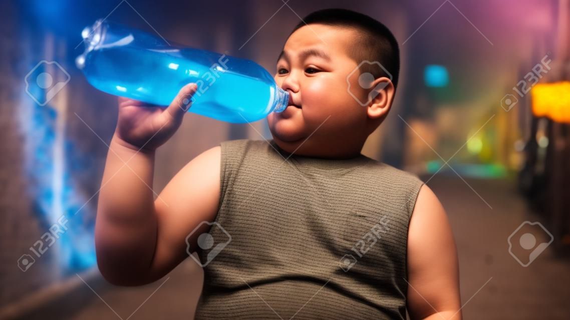 Asian Fat boy is drinking a cola