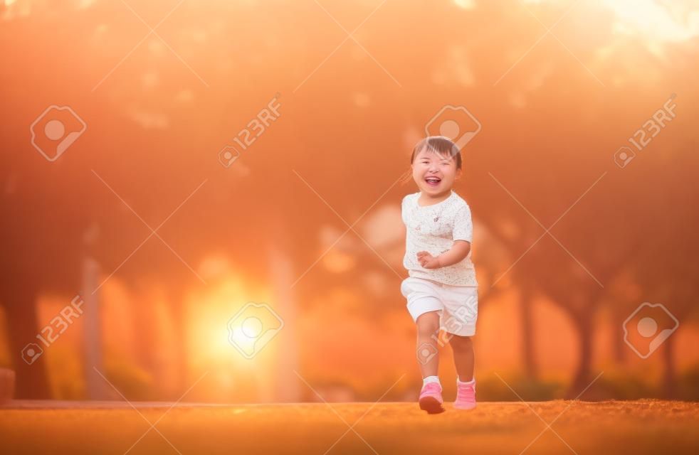 Happy baby asian girl smiling. little girl running and smiling at sunset happy baby girl smiling. little baby running at sunset. cute baby running at playground garden.