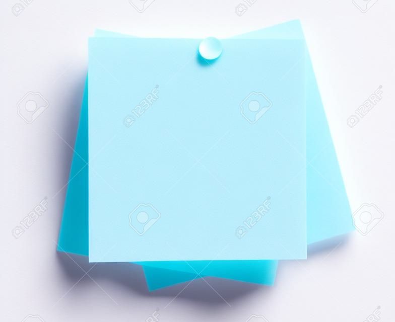 Closeup or macro of a set of blank sticky notes with pushpin isolated on white seamless background
