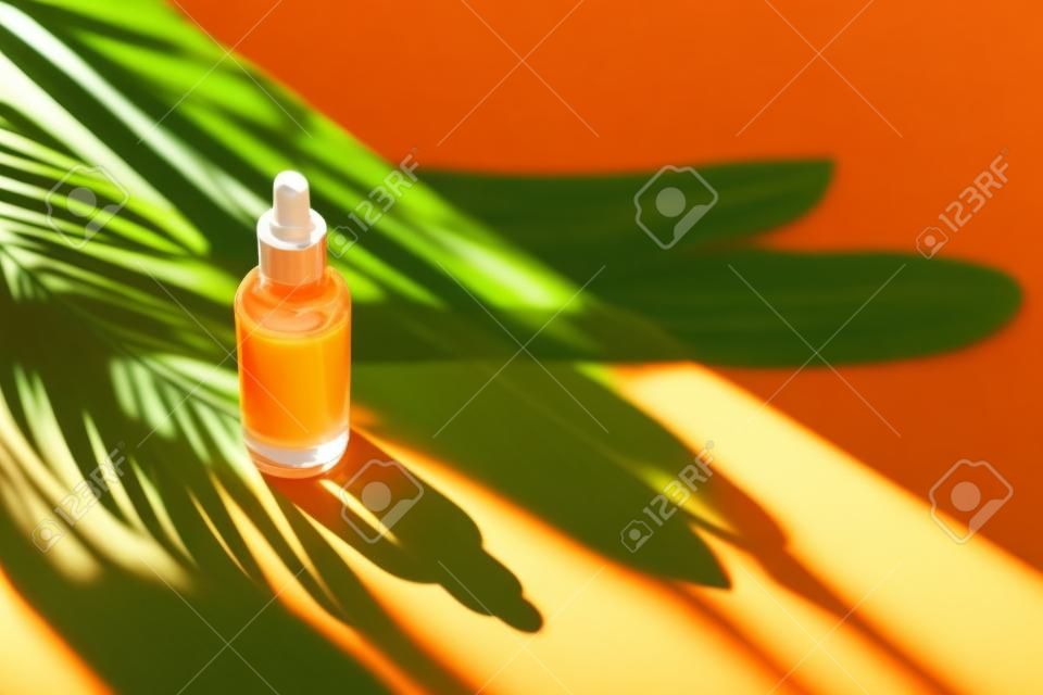 Luz solar natural e sombras de plantas tropicais. Fundo laranja com luz do dia. Produtos de cuidados com a pele, cosméticos naturais. Conceito de beleza para cuidados com o rosto e o corpo