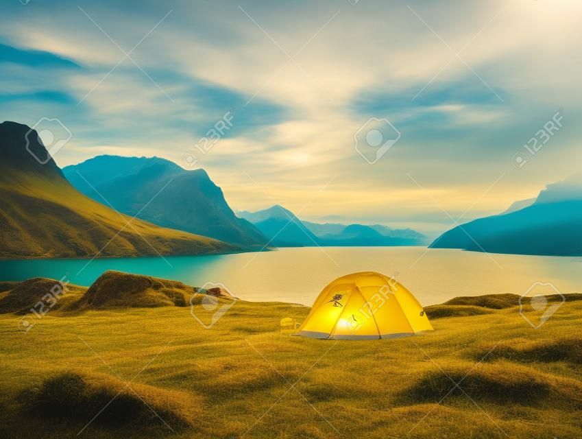 a yellow tent next to a body of water