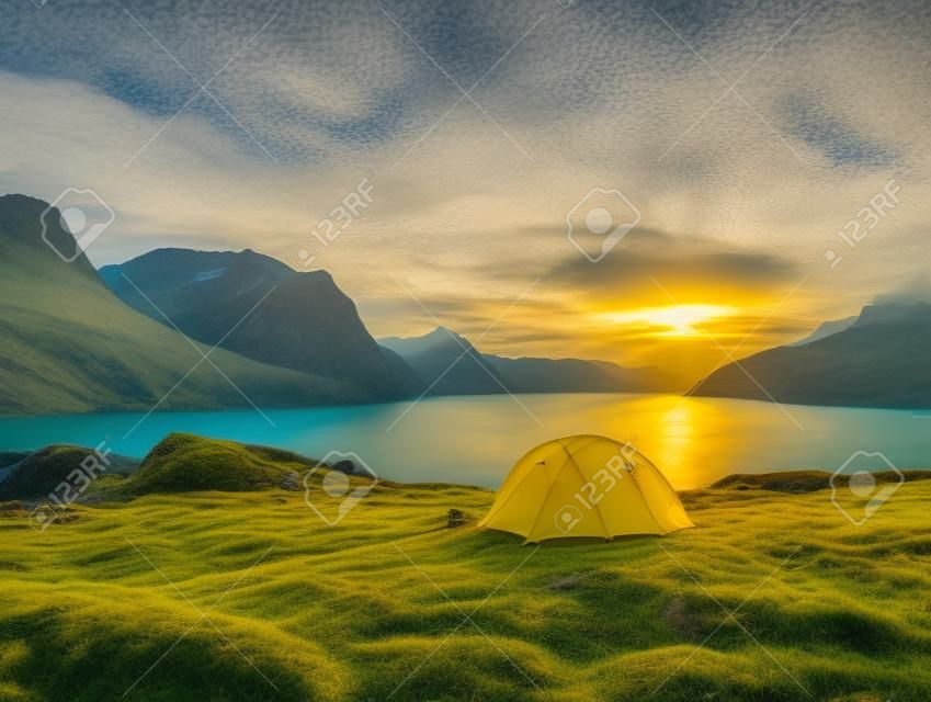 a yellow tent next to a body of water