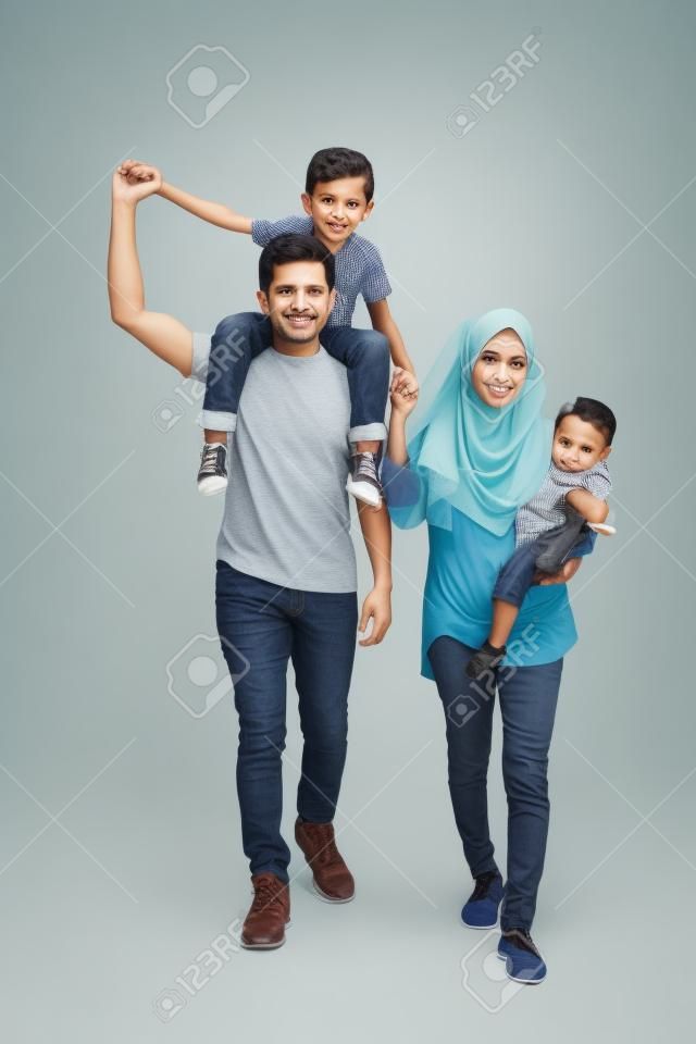 O comprimento total da família muçulmana andando no estúdio enquanto o pai carregava seu filho no ombro