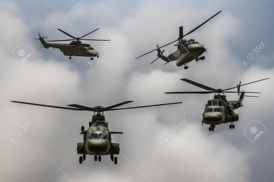 Photo of four military helicopters flying together while doing demonstrations, isolated on white background