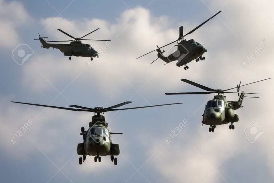 Photo of four military helicopters flying together while doing demonstrations, isolated on white background