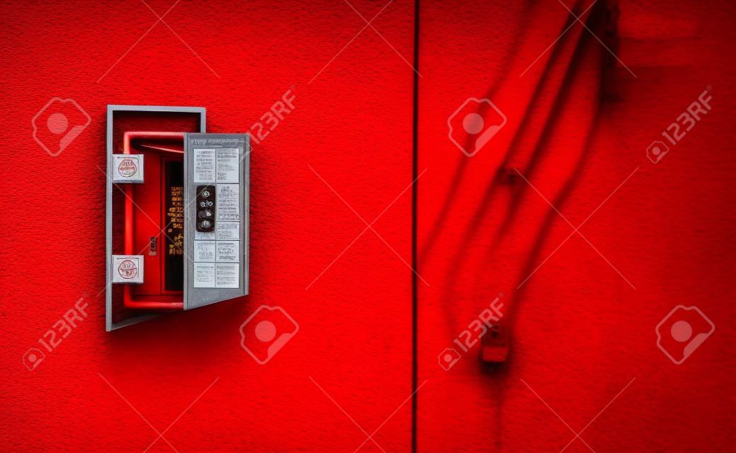 The red fire alarm switch on the red wall at the Bangkok subway.