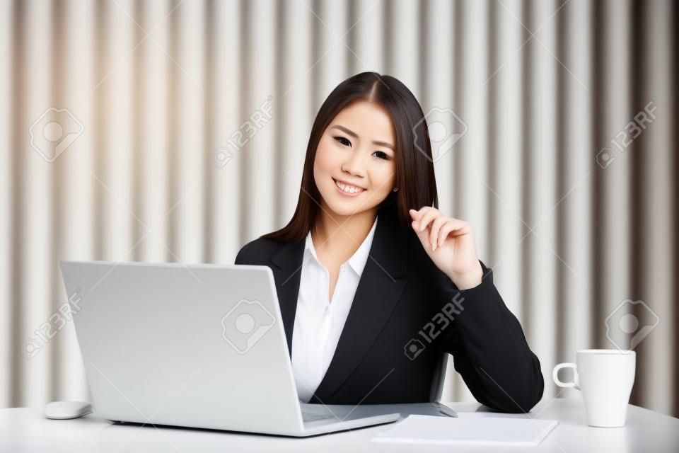 肖像使用筆記本電腦在辦公室的年輕女商人