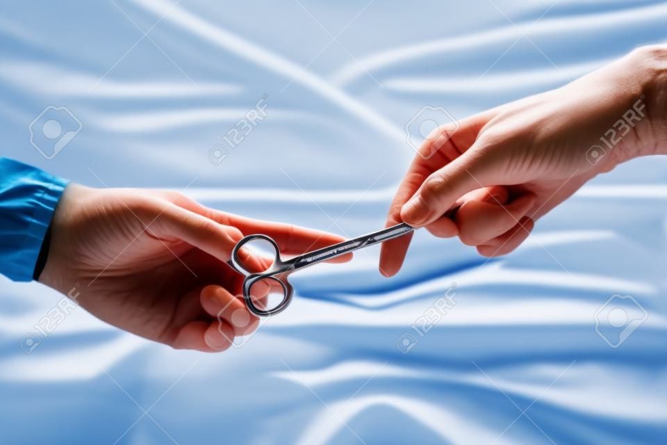 opieki zdrowotnej i medycznej koncepcji, Close-up z rąk chirurgów trzymając nożyczki chirurgiczne i przekazywanie sprzętu chirurgicznego, Rozmycie tła.