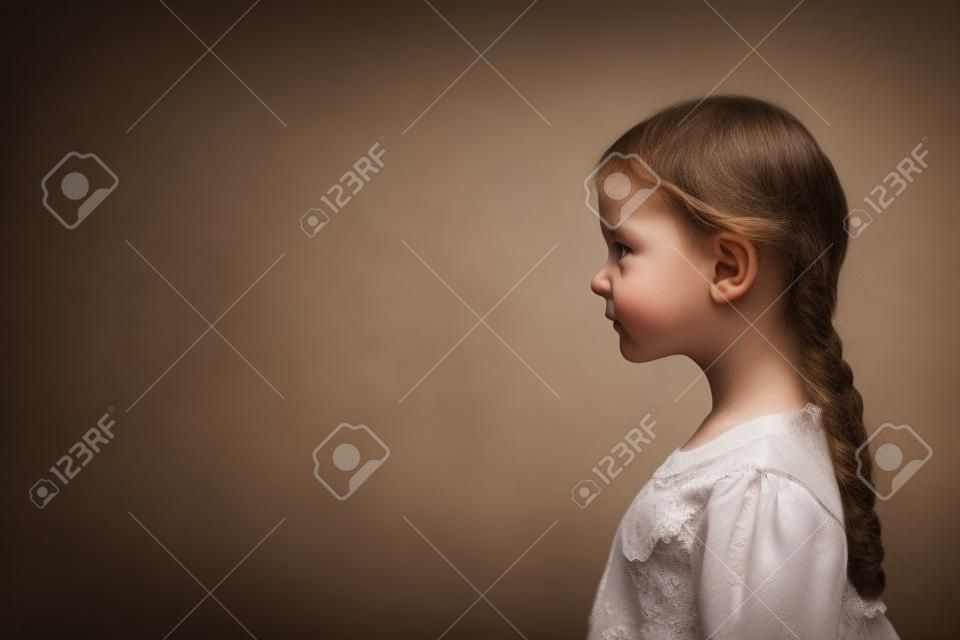 Retrato de niña pobre posando en perfil