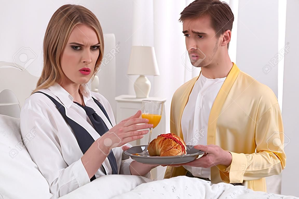 Non, merci. Femme dominante insatisfaite portant une cravate et son mari lui apportant son petit déjeuner