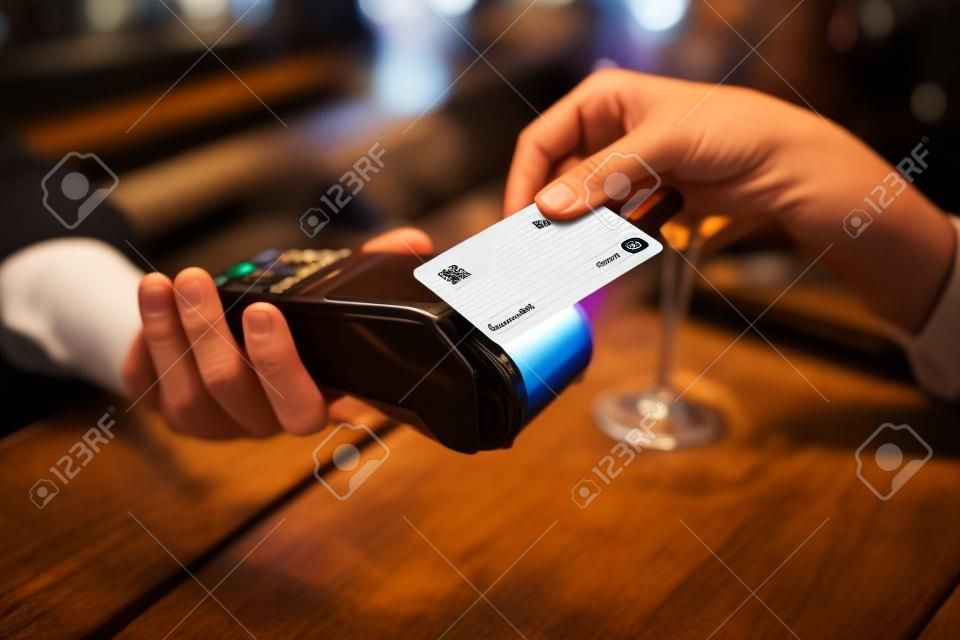 Club card. Regular client using club card while paying for the bill in the bar