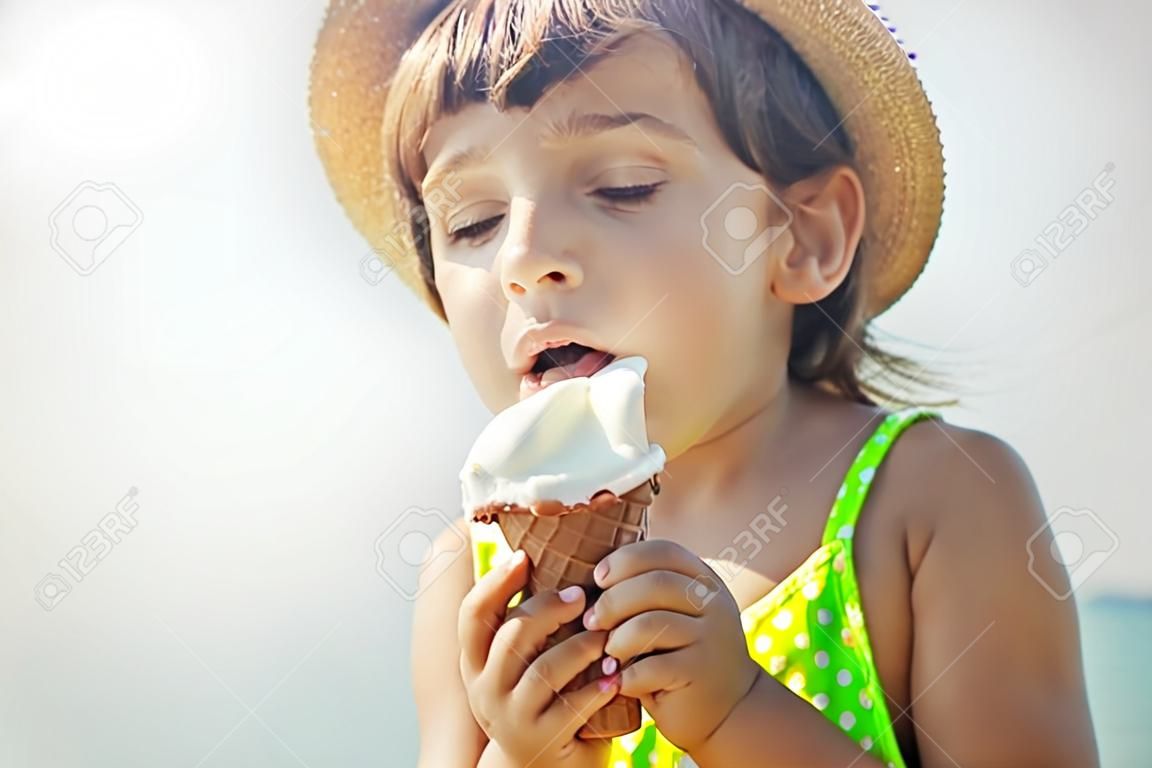 Das Kind isst Eis auf dem Meer. Selektiver Fokus. Sommer.