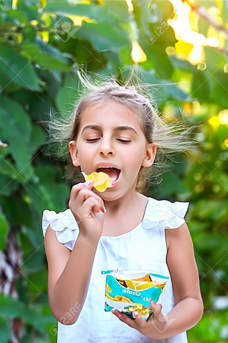 Das Kind isst Chips. Selektiver Fokus. Kind.