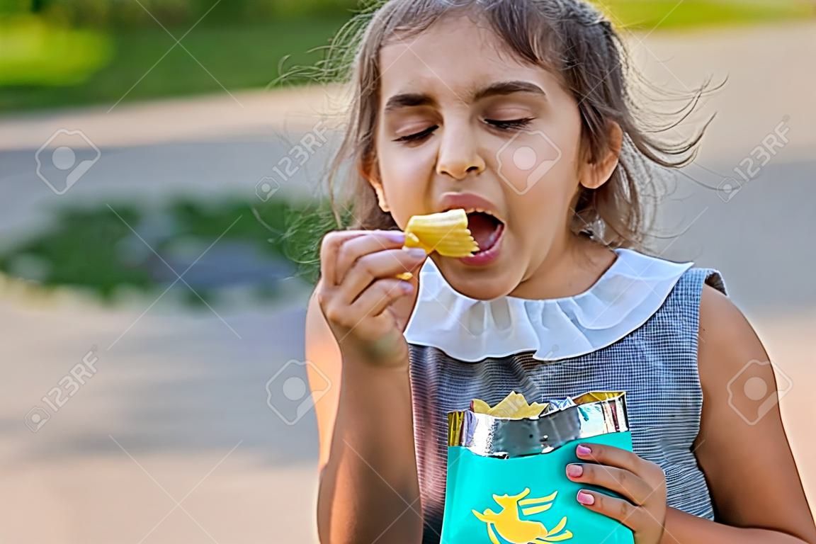A criança está a comer batatas fritas.