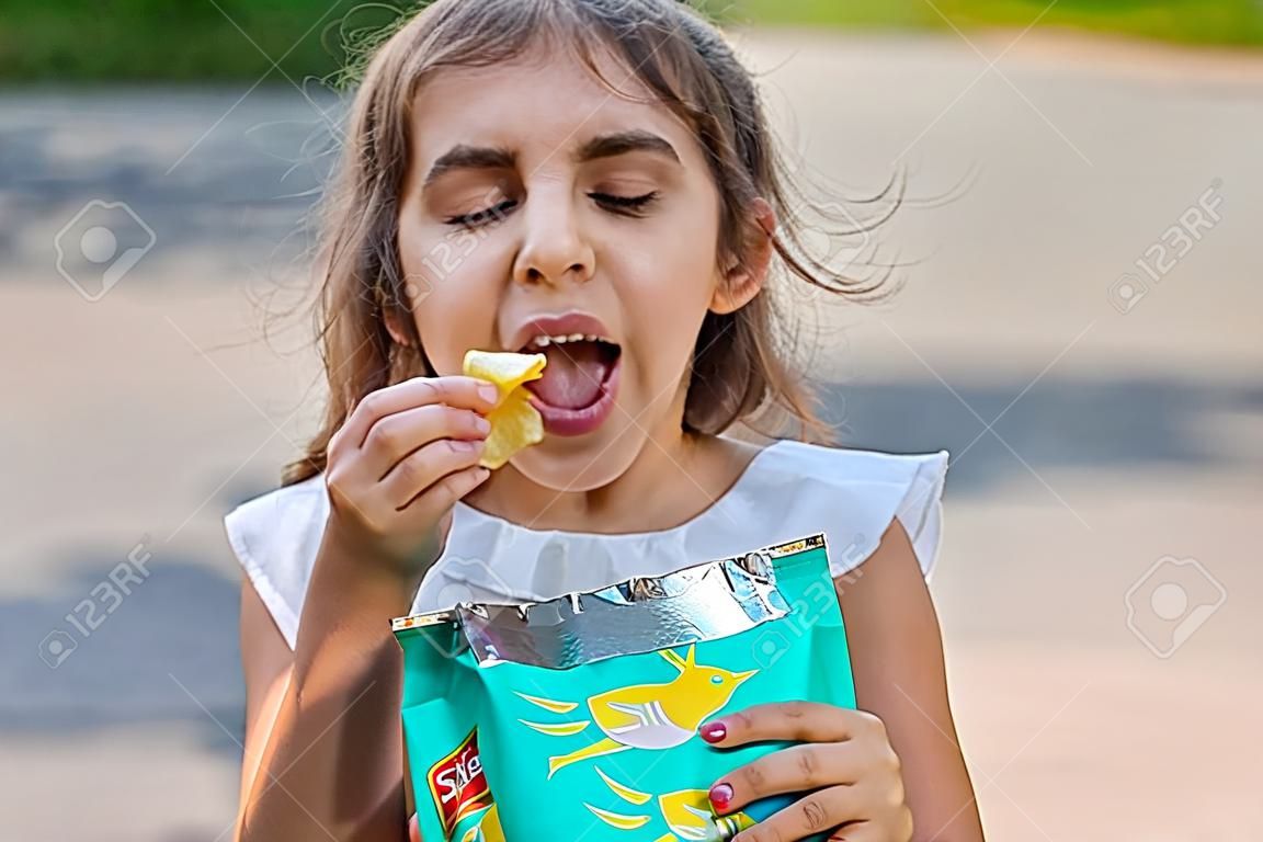 A criança está a comer batatas fritas.