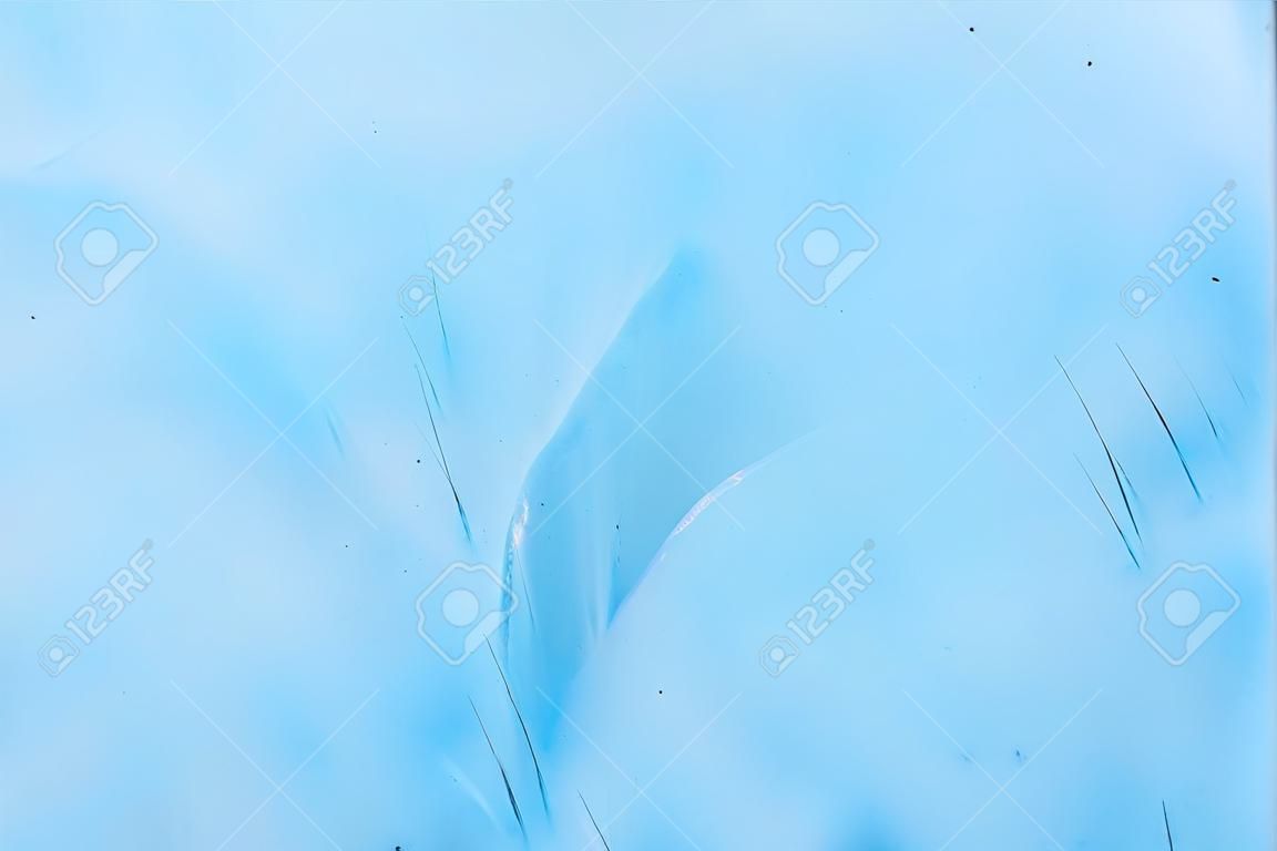 Primer plano de la pared borrosa de un glaciar centenario con una estructura de rayas y burbujas. Textura ligera azul hielo