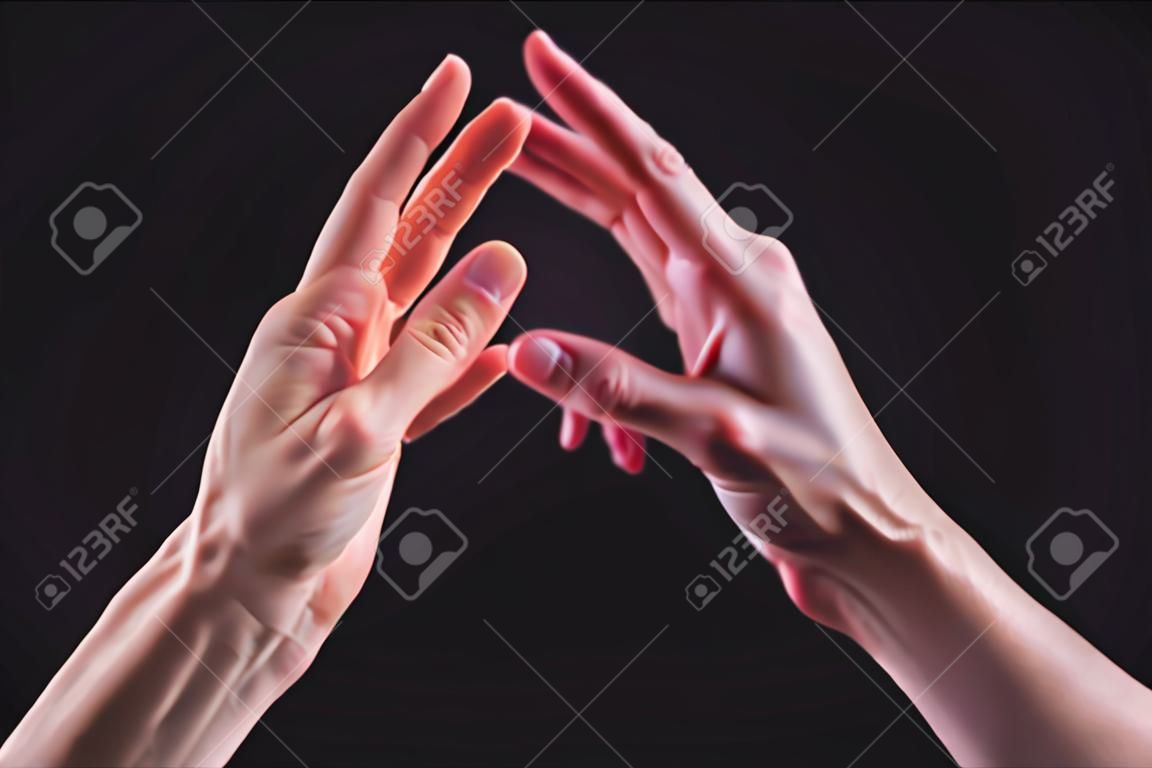 Um close-up de duas mãos macho e fêmea tocam suavemente um ao outro. O conceito de rejeição trémula entre os sexos