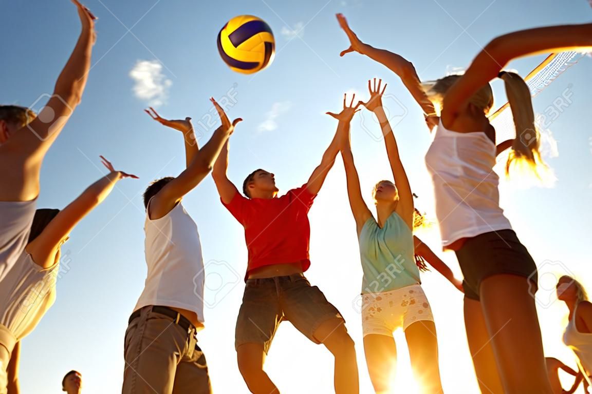 grupo de jóvenes jugando voleibol en la playa