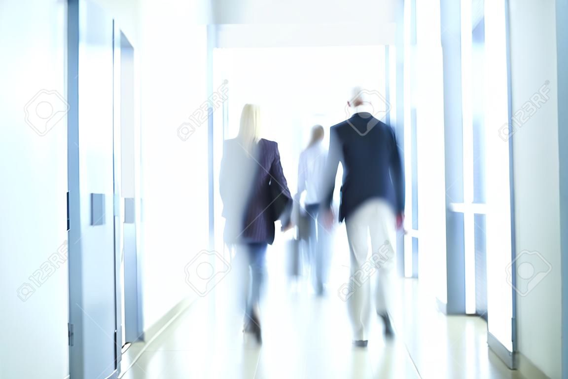 empresarios caminando por el pasillo de, un centro de negocios desenfoque de movimiento pronunciado