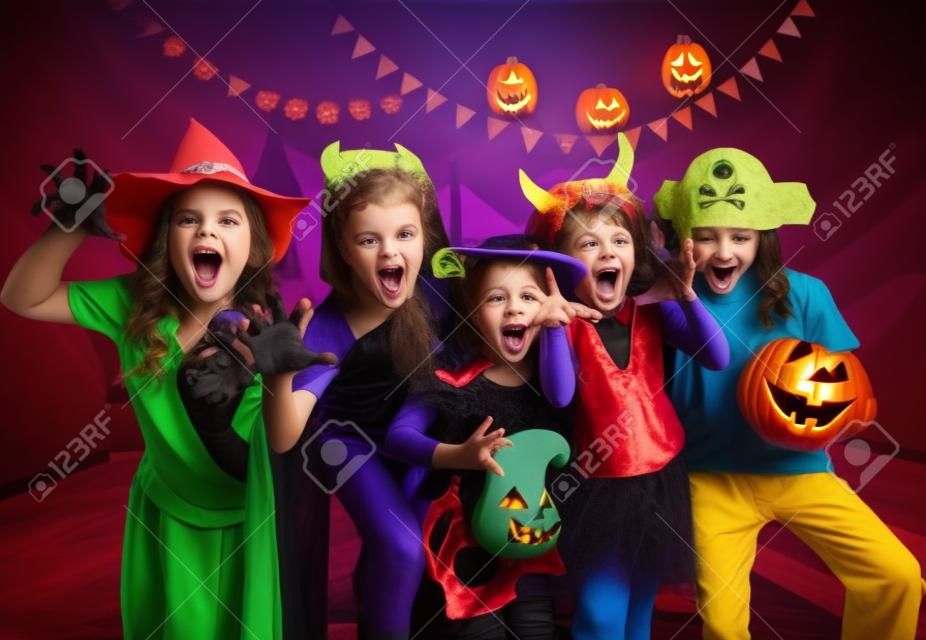 group of funny  children in costume celebrate together a halloween party