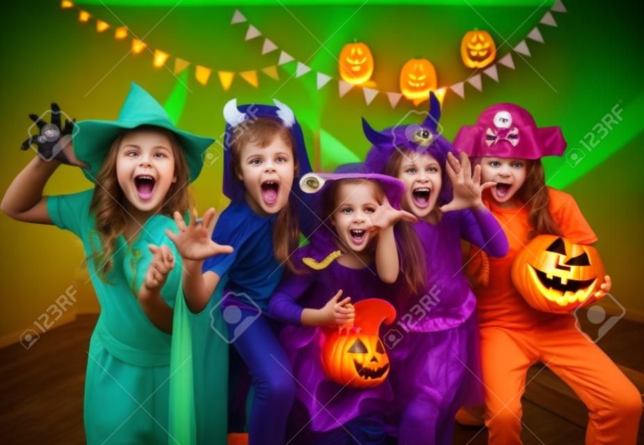 group of funny  children in costume celebrate together a halloween party