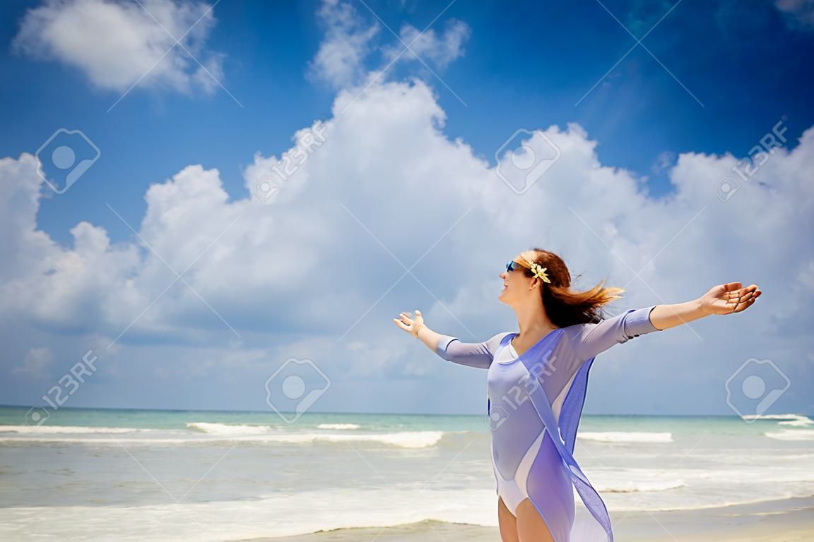 Glückliche Frau, die am Strand genießen