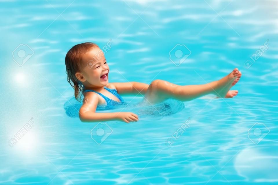 Glückliches Kind, das im Swimmingpool spielt. Ferien-Konzept