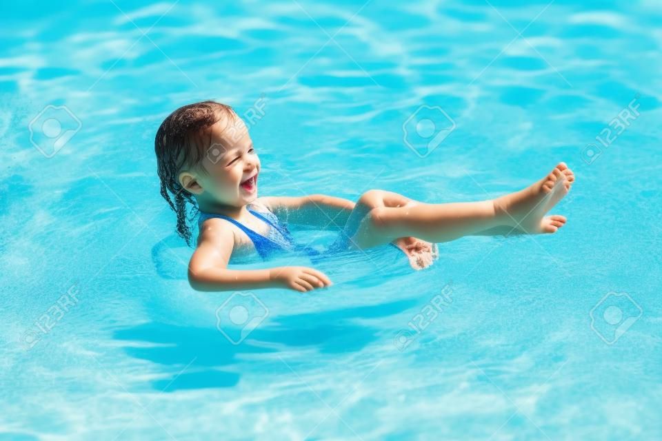 Gelukkig kind spelen in het zwembad. Zomer vakantie concept