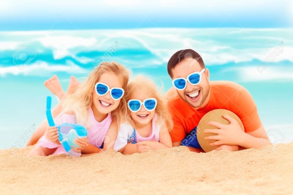 Familia feliz jugando en la playa. Concepto de las vacaciones de verano