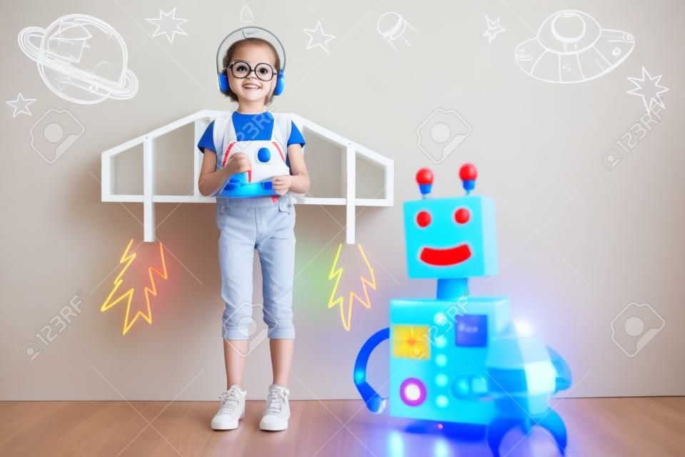 Cabrito feliz que juega con el robot de juguete en casa. La innovación tecnológica y el concepto de éxito