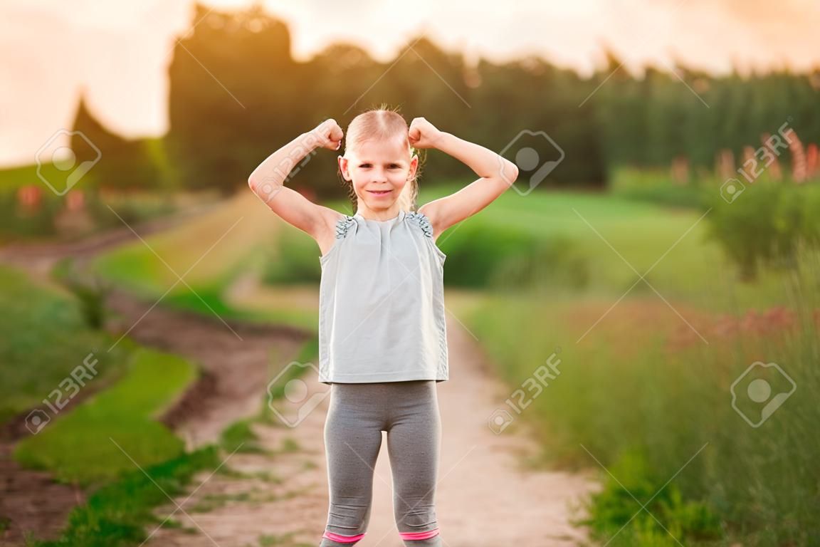 Child cute girl show biceps gesture of power and strength outdoor. Feel so powerful. Girls rules concept. Strong and powerful.