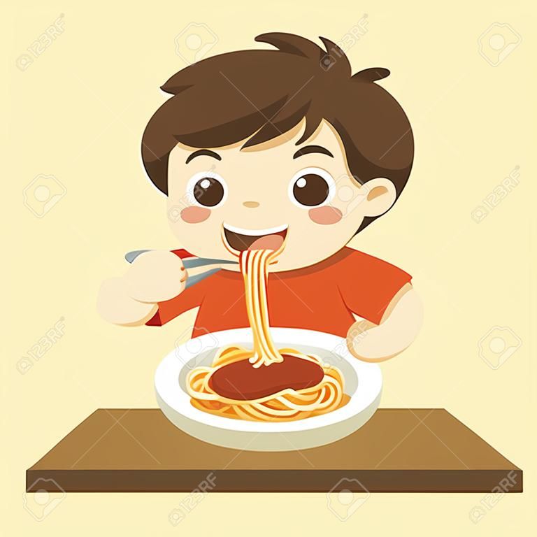 Mały chłopiec chętnie je spaghetti z widelcem na talerzu.