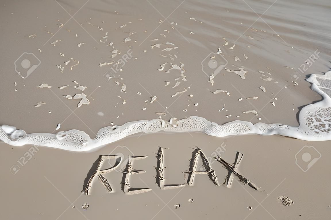 inscription Relax on a sand and a wave