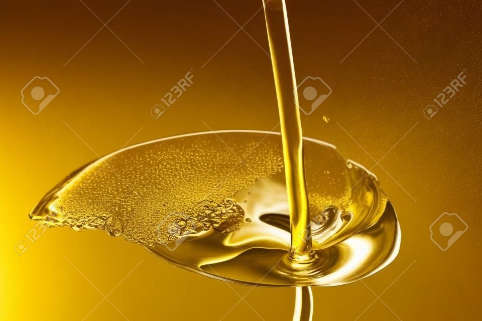 Verser l'huile d'or liquide fermer up vue