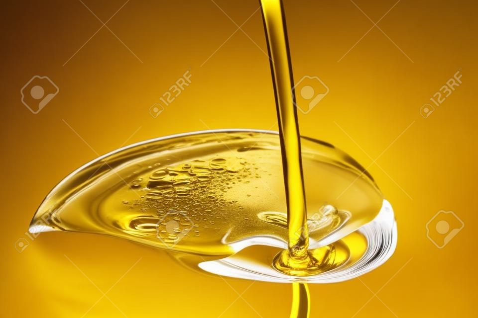 Vloeibare gouden olie uitschenken close up view