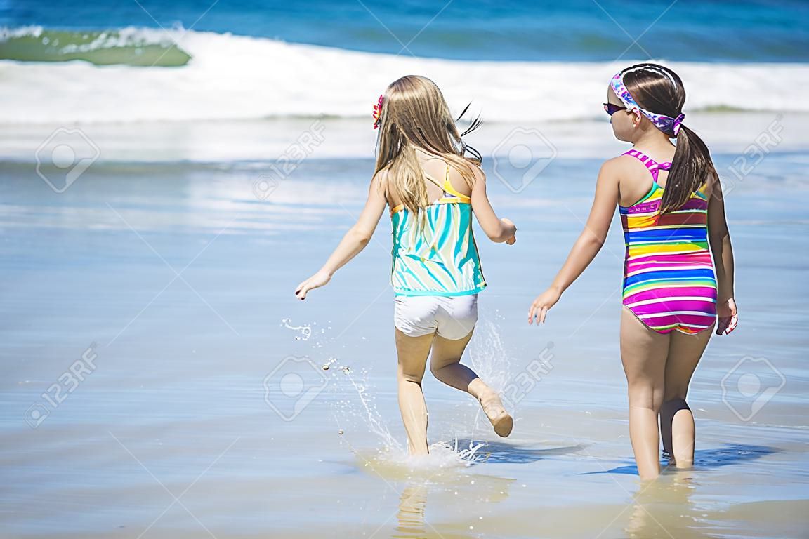 petites filles mignonnes jouant à la plage ensemble pendant les vacances d'été