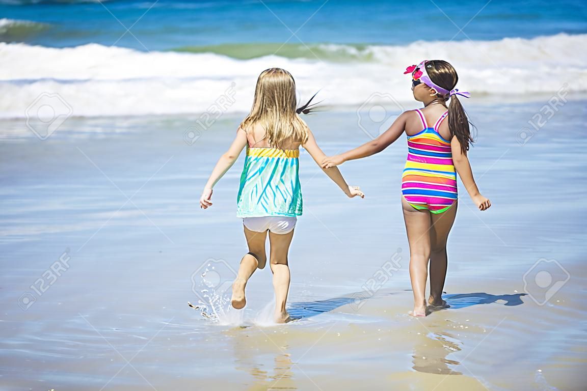 cute niñas pequeñas que juegan en la playa juntos durante las vacaciones de verano
