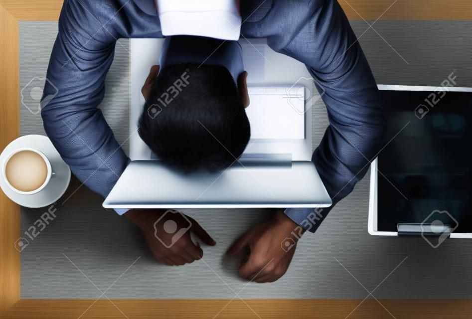Middeleeuwse Aziatische zakenman zich slaperig voelen tijdens het werken op laptop en vergadering op cafÃ© kantoor